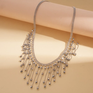 Detail view of tiered silver fringe necklace with faceted metallic bead tassels