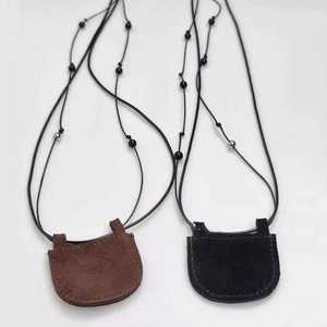 Detail of brown and black suede mini crescent bag necklaces with beaded straps