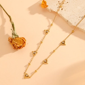 Gold-plated stainless steel heart necklace with cubic zirconia and bead chain on stone
