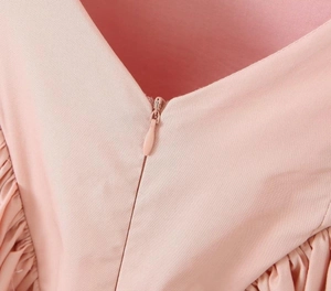 Macro detail of high-quality invisible zipper on a pink bow tie waist dress
