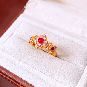Detailed macro of vintage 24K gold plated ring with purple enamel and red gemstone