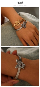 Detail of 18K gold and silver double butterfly open bangles with triple band design