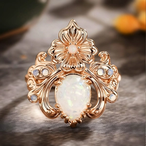 Détail macro d'une bague florale en or rose avec une opale poire et des motifs de feuilles