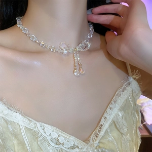 Close-up of a clear crystal bead bow necklace with elegant double tassel pendants