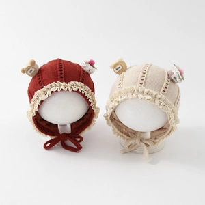 Infant knit bonnets with lace edges, smile bear patches and adjustable chin straps