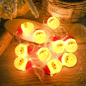 Christmas LED string lights with Santa Claus heads emitting a warm glow on cedar branches