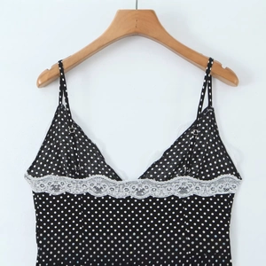French retro black polka dot camisole dress with white lace neckline trim on wooden hanger