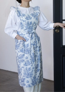 Detail of blue and white vintage floral cotton apron with ruffled straps and front pocket