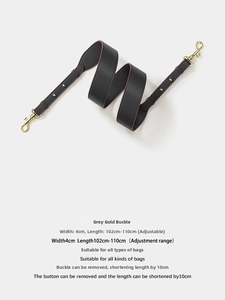 Detail of adjustable 4cm wide grey leather shoulder strap with gold metal hooks and buckle