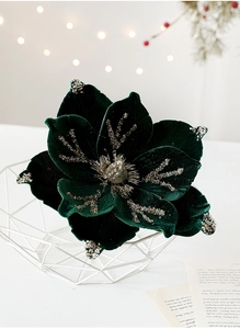 Detail of dark green velvet magnolia flower with silver glitter veins in a metal basket