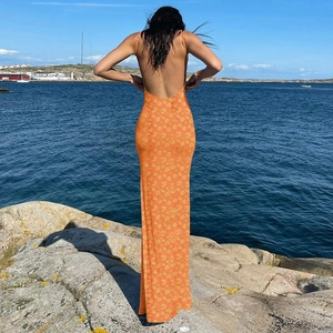 Détail montrant le design dos nu et l'imprimé fleuri sur la robe longue orange ajustée