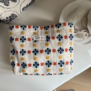 Detail of floral embroidery on linen canvas pouch featuring simple wish fabric label