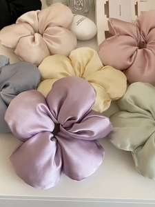 Detail view of colorful satin flower scrunchies with elegant silk texture and soft folds