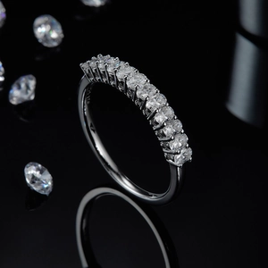 Macro shot of polished S925 silver moissanite eternity ring on reflective black background