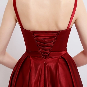 Élégante robe de soirée en satin rouge foncé avec un dos croisé à lanières et une texture soyeuse
