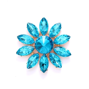 Broche fleur dorée ornée de cristaux bleu sarcelle et strass en tournesol