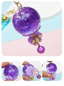 Detailed close-up of a purple resin dried flower ball charm with butterfly and glitter bell