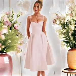 Détail d'une robe midi rose dos nu avec taille cintrée et ourlet évasé décoré de fleurs