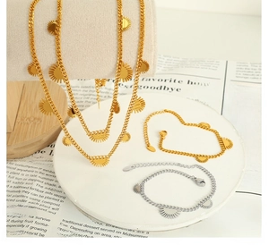 Set aus Gold- und Silber-Cuban-Ketten mit Sonnenanhängern auf stilvollem Display