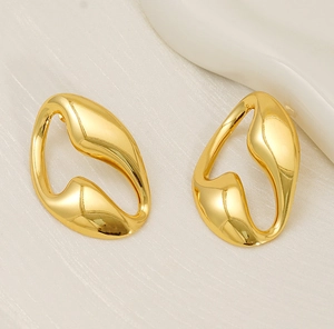 Detailed close-up of gold irregular geometric hollow earrings with a molten metal texture