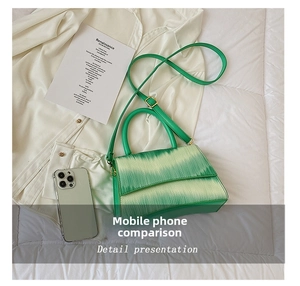 Crocodile pattern green crossbody bag shown with a smartphone for size reference