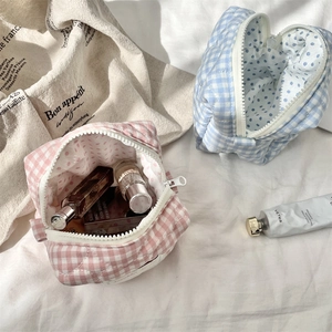 Detailed view of quilted cotton cosmetic bags in pink and blue plaid patterns