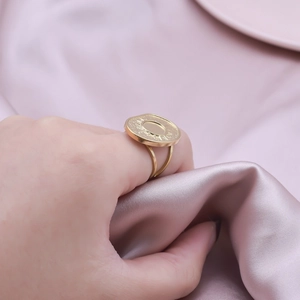 Detailed macro view of a gold double-layer adjustable ring with sunburst engraved disc
