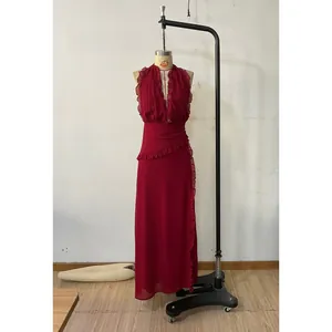 Detail of red halter maxi dress with elegant ruffle trim and deep V-neckline
