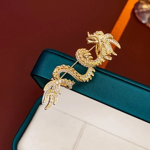 Detail of gold-plated dragon brooch with sparkling white zircons on a jewelry box