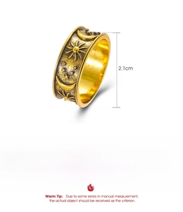 Macro detail of vintage celestial alloy ring showing sun, moon and star relief carvings