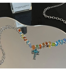 Detail of colorful stone patchwork necklace with blue cross pendant on silver chain
