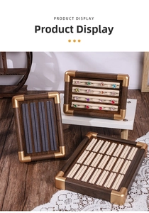 Detailed view of walnut wood jewelry display trays with gold metal edges and plush inserts