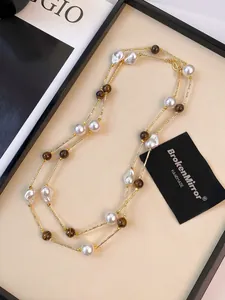 Detailed macro of double-layer necklace with baroque pearls and tiger eye stone beads