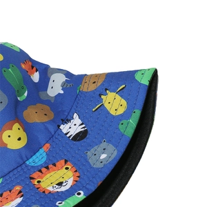 Détail d'un chapeau bob bleu en coton avec des imprimés de lion et de zèbre en dessin animé