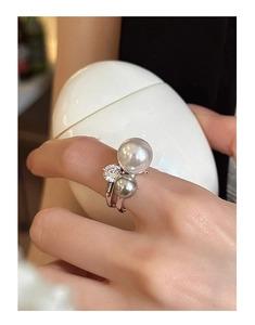 Detailed view of an irregular pearl and zircon ring with a modern adjustable silver band