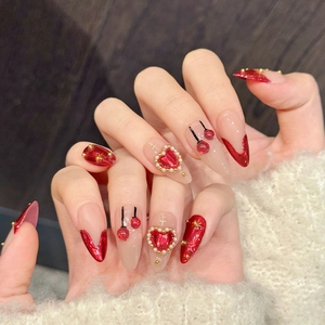 Handmade almond press-on nails in burgundy red with pearl hearts and cherry patterns