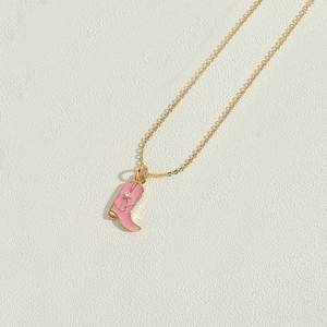 Detailed close-up of a pink enamel cowboy boot pendant on a 14K gold-plated star necklace