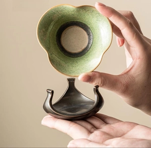 Ceramic tea strainer set with kiln-fired glaze and tripod base in hands