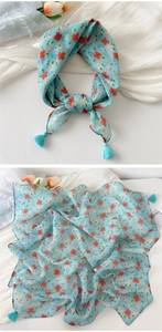 Detail of lake blue cotton linen scarf featuring orange floral patterns and corner tassels