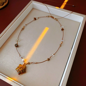 Détail du pendentif étoile en oeil de tigre avec perles et cordon en cristal