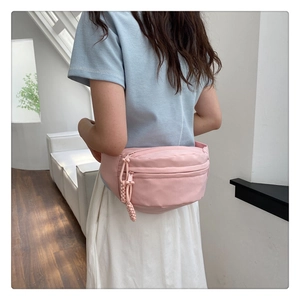Detailed back view of a pink nylon fanny pack on a model in minimalist attire