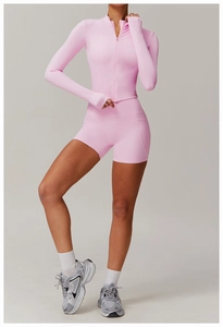 Detail der rosa Fitnessjacke mit Reißverschluss und Shorts mit hoher Taille am Model
