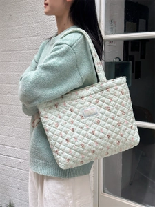 Detail of mint green quilted tote bag with rabbit print and Sarakka Studio woven label