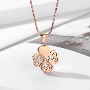 Macro detail of rose gold four-leaf clover pendant with sparkling diamonds and hollow pattern