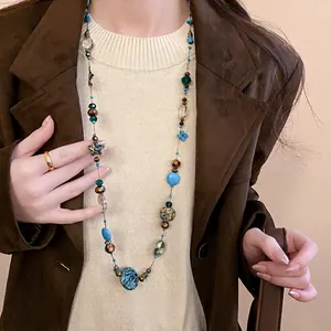 Bohemian multilayered long necklace with turquoise beads and metallic floral charms
