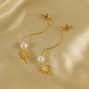 Elegant gold octagram star drop earrings with white pearls on a luxury silk background