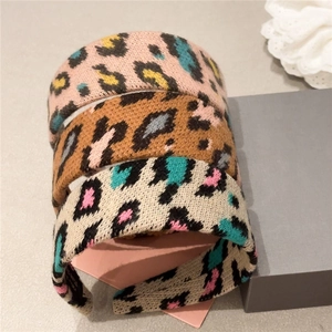 Detailed view of plush leopard print headbands in pink, brown and beige knit