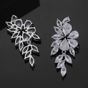 Macro shot of silver drop earrings with marquise zircon leaves and floral crystal details