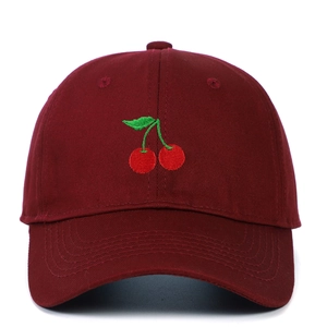 Close-up of premium cherry embroidery on dark red cotton twill baseball cap fabric