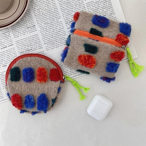 Detail of plush coin purses with colorful pom-poms and green woven zipper puller